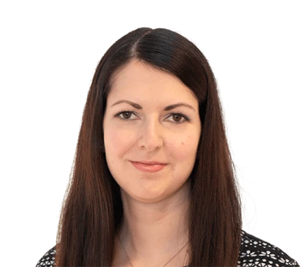 Julia Multhammer from Max Frank looks friendly into the camera. She has long, straight, dark brown hair with a center parting and is wearing a top with a black and white pattern.