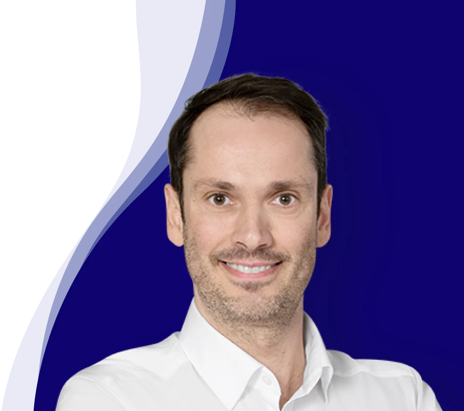 Bernhard Maier smiles at the camera. He is wearing a white shirt with an open collar. He has short, dark brown hair and a slight shadow of a beard. The background has a modern design with curved waves in dark blue, white and light blue.